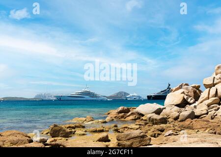 Vue imprenable sur quelques yachts de luxe naviguant sur une eau turquoise pendant une journée ensoleillée. Baie de Cala di volpe, Costa Smeralda, Sardaigne, Italie Banque D'Images