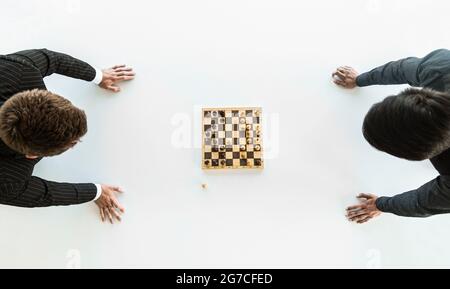 deux hommes d'affaires, rivaux, jouent aux échecs. Stratégie et rivalité. Banque D'Images