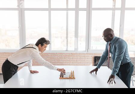 deux hommes d'affaires, rivaux, jouent aux échecs. Stratégie et rivalité. Banque D'Images