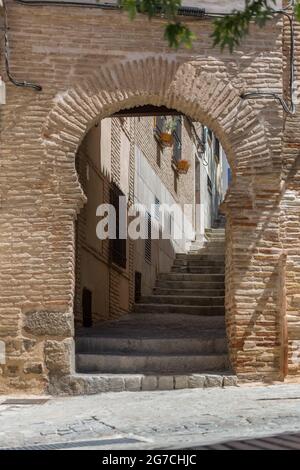 Vue détaillée d'une porte de style mauresque sur un bâtiment de façade avec un passage en fer à cheval menant à une rue d'escalier, architecture arabe avec un ornement décoratif Banque D'Images