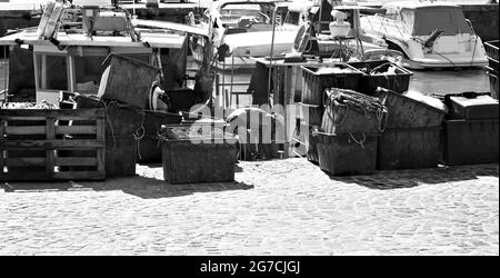 Pesaro, Italie - 09 juillet 2020 : un pêcheur travaille sur son bateau de pêche au port de Pesaro avec les outils du commerce, les filets de pêche et les boîtes Banque D'Images