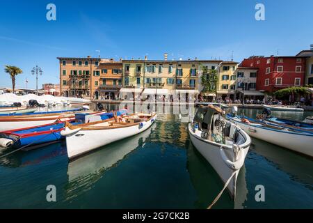 Petit port du village de Lazise avec bateaux de pêche, station touristique sur la côte du lac de Garde (Lago di Garda). Vérone, Vénétie, Italie, Europe. Banque D'Images