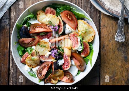 Salade de figues fraîches et de mozzarella avec tranches de pêche grillées et tomates Banque D'Images