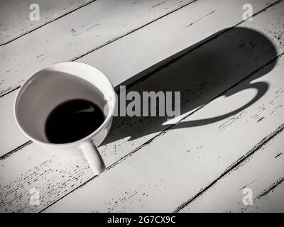 Tasses à café sur table en bois blanc de style vintage noir et blanc. Banque D'Images