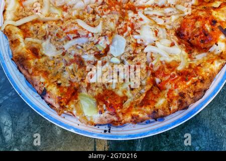 Vue de dessus d'une délicieuse pizza cheesy coupée en tranches égales servies sur un PLA blanc et bleu en céramique Banque D'Images