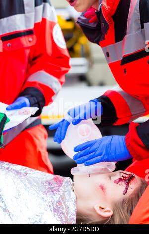 Médecin d'urgence et les infirmières de l'équipe d'ambulance ou de l'oxygène à une victime d'un accident donnant Banque D'Images