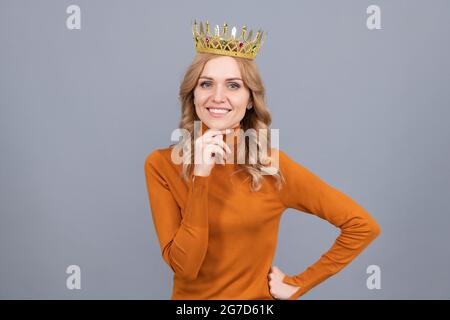 portrait de gloire. femme blonde souriante dans la couronne. reine confiante. soupiré Banque D'Images