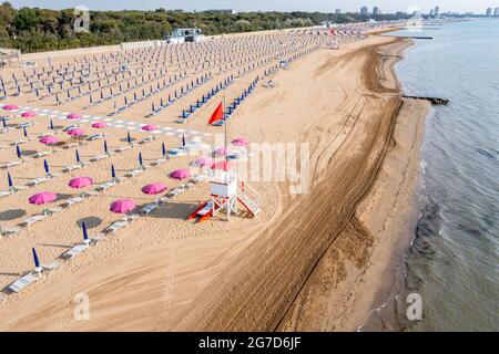 Plage de Lignano au bord de la mer Adriatique en Italie, en Europe pendant l'été. Il y a plein de transats vides et de parasols de plage. Banque D'Images