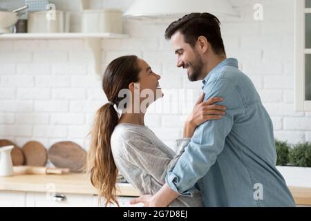 Beau couple dans la danse d'amour dans la cuisine moderne lumineuse Banque D'Images