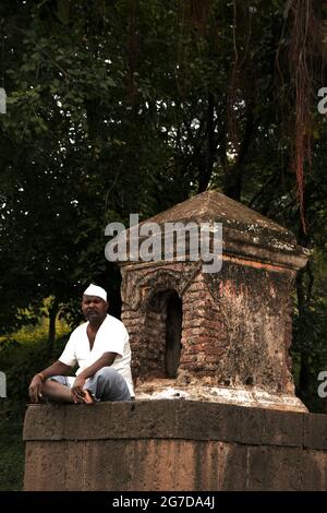 11 juillet 2021 à Mardhe Village, Satara, Inde. Old Man indien non identifié assis devant le petit Temple le matin, style de vie rural. Village indien Banque D'Images