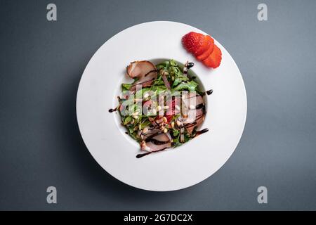 vue de dessus de salade avec arugula, jambon de viande et fraise sur fond noir Banque D'Images