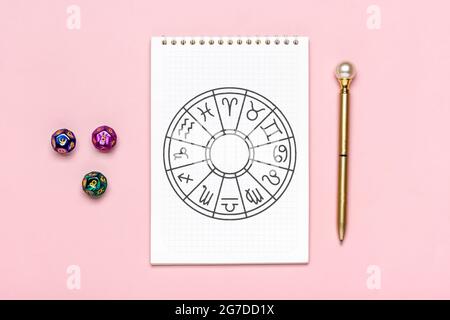 Horoscope cercle avec douze signes de zodiaque sur le papier, divination dice, pierre colorée sur fond rose la narration de Fortune et prédictions d'astrologie Banque D'Images