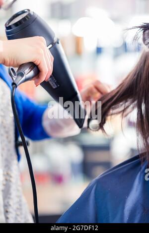 Coiffeur femme sécher les cheveux des femmes avec séchoir à shop Banque D'Images