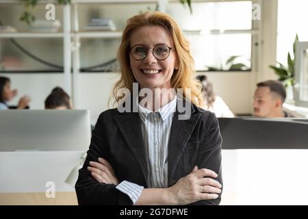 Bonne femme d'affaires senior, leader dans les lunettes regardant la caméra Banque D'Images