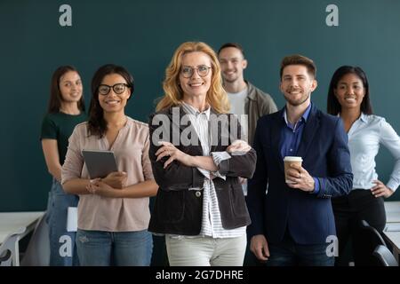 Bonne femme d'affaires senior posant avec un groupe multiethnique d'employés Banque D'Images