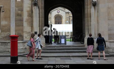 Scène de rue avec plusieurs personnes regardant à travers un Archway et entrée Corpus Christi College, Cambridge University, Grande-Bretagne Banque D'Images