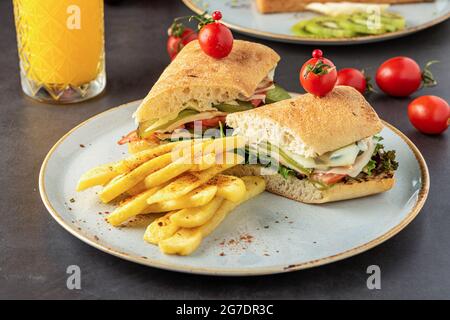 sandwich au jambon, au fromage et à la tomate avec frites et jus d'orange. Banque D'Images