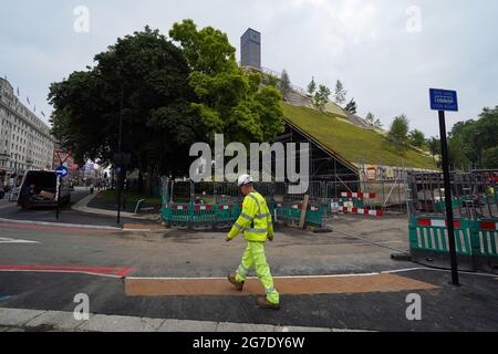 Les travaux se poursuivent sur le Marble Arch Mound dans le centre de Londres. Le sommet de la nouvelle installation de 25 mètres de haut offrira des vues panoramiques sur Hyde Park, Mayfair et Marylebone lors de son ouverture au public en juillet. La colline artificielle a été construite sur une base d'échafaudage, avec des couches de sol et de contreplaqué formant le monticule qui a un centre creux avec de l'espace pour les expositions et les expositions. Date de la photo: Mardi 13 juillet 2021. Banque D'Images