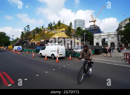 Les travaux se poursuivent sur le Marble Arch Mound dans le centre de Londres. Le sommet de la nouvelle installation de 25 mètres de haut offrira des vues panoramiques sur Hyde Park, Mayfair et Marylebone lors de son ouverture au public en juillet. La colline artificielle a été construite sur une base d'échafaudage, avec des couches de sol et de contreplaqué formant le monticule qui a un centre creux avec de l'espace pour les expositions et les expositions. Date de la photo: Mardi 13 juillet 2021. Banque D'Images