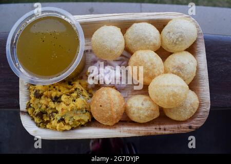 Délicieux en-cas indiens Pani puri avec de l'eau de chat masala et des oignons en tranches. Plat de collation indien traditionnel également connu sous le nom de boules d'eau, Golgappe, puchka. Banque D'Images