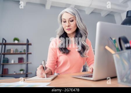 Photo de sérieux calme attrayant vieille femme écrire ordinateur portable plan à l'intérieur de la maison bureau plat Banque D'Images