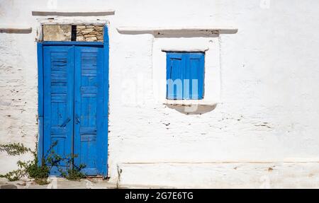 Cyclades Grèce. Petite maison blanche avec porte et fenêtre de couleur bleue, cadres en bois sur murs blanchis à la chaux à Sifnos. Architecture de l'île grecque, espace de copie Banque D'Images