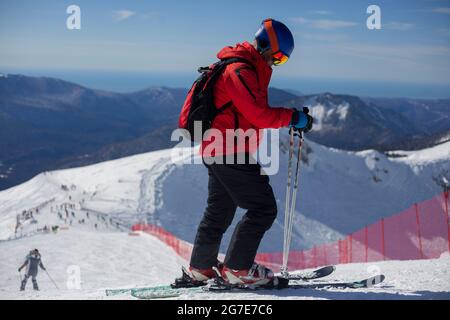 Un skieur se déplace sur une pente enneigée. Repos actif en hiver. L'athlète se prépare à la descente. Station de ski de montagne. Activités de plein air sur une Wint Banque D'Images