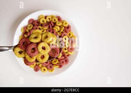 céréales cheerios dans un bol avec cuillère isolée sur fond blanc, assiette de délicieux anneaux, concept de petit déjeuner sain, vue du dessus Banque D'Images