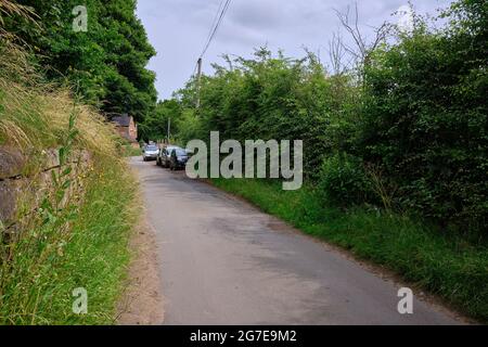 Voitures garées sur Common Lane dans les nottes rurales Banque D'Images