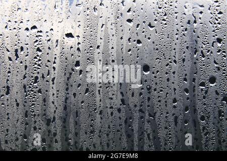 Texture des gouttes de pluie sur une surface humide et transparente. Verre embué. Banque D'Images