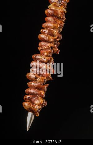 Coeur de poulet barbecue sur brochettes sur fond noir. Gastronomie brésilienne. Banque D'Images