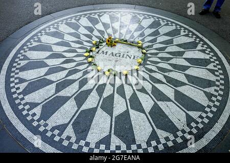 Les touristes rendent hommage à John Lennon au mémorial de Strawberry Fields, à Central Park, à New York. Banque D'Images