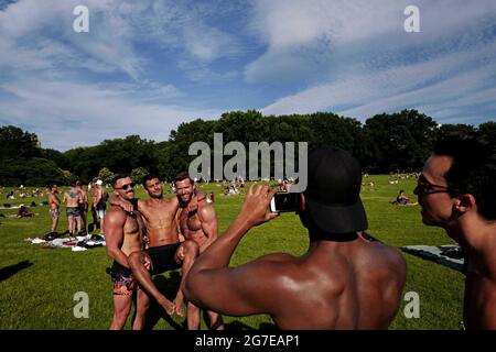 Maillots de bain les gars se rassemblent à Central Park lors d'un été chaud samedi après-midi, à New York. Banque D'Images