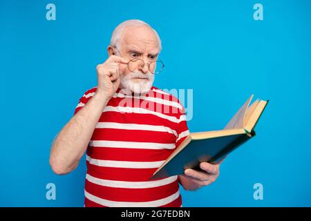 Portrait de l'homme attrayant fou strict gris-cheveux lecture science livre isolé sur fond bleu clair de couleur Banque D'Images