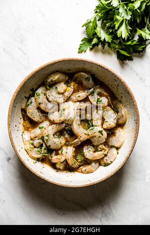 Crevettes dans une marinade maison, sur fond de marbre Banque D'Images