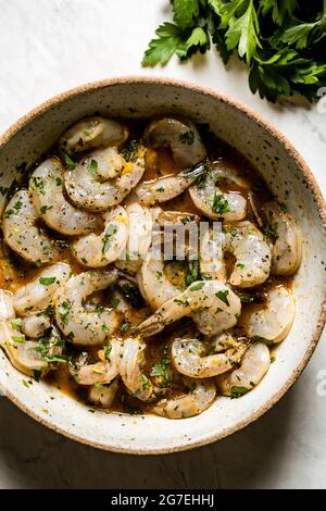 Crevettes dans une marinade maison, sur fond de marbre Banque D'Images