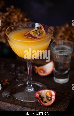Un martini aux fruits de la passion (Maverick) recouvert d'un quart de fruits de la passion et servi avec du vin mousseux Banque D'Images