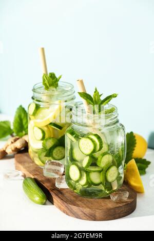 Détox d'été et boissons rafraîchissantes avec concombre, citron, menthe et gingembre sur fond de mur de briques blanches. Boissons rafraîchissantes en été, boissons à la mode Banque D'Images