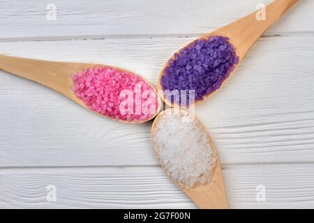Three wooden spoons with colored salt of different color. Banque D'Images