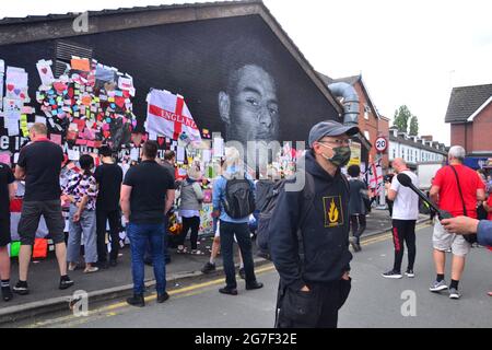 L'artiste de rue Akse étant interviewé devant la murale géante du joueur de Manchester United Marcus Rashford à Withington, Manchester, Angleterre, Royaume-Uni, qu'il a peint. La fresque a été vandalisée par des graffitis abusifs après la défaite de l'Euro2020 en Angleterre le 11 juillet 2021. La fresque a été créée par l'artiste de rue d'origine française Akse sur le mur du café de la Maison du café sur la rue Copson. Marcus Rashford est un joueur de football de Manchester United. Akse a entièrement réparé la peinture murale endommagée avant le 13 juillet 2021. Date de la photo : 13 juillet 2021. Banque D'Images