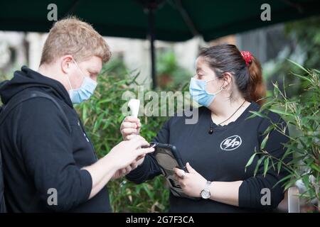 Londres, Royaume-Uni, 13 juillet 2021 : les touristes sur la rive sud apprécient de se promener sur la Tamise, de visiter le marché de Borough ou le Globe Theatre. À l'intérieur du marché, les gens sont invités à porter des masques, mais pas tous. Certains cafés ont des contrôles de température à la porte, mais une fois assis, les clients prennent leur masque pendant que le personnel d'attente garde leur. Anna Watson/Alay Live News Banque D'Images