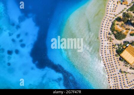 Vue aérienne sur la plage de sable, arbres verts, montagne au coucher du soleil Banque D'Images