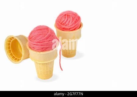 Boules de fils roses en cônes de crème glacée isolés sur fond blanc Banque D'Images