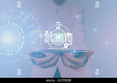 Femme dans une tablette de maintien uniforme montrant une interface virtuelle futuriste. Lady en costume utilisant un appareil Pencil Mobile interagir avec holographique Banque D'Images