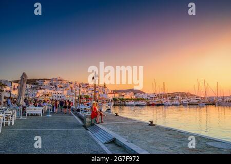 PAROS, CYCLADES, GRÈCE - JUIN 2018: Touristes marchant et prenant des photos le long du village de bord de mer de Naousa sur l'île de Paros, Cyclades, Grèce, Banque D'Images