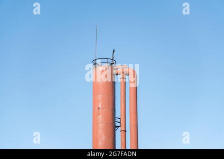 Sommet d'une tour cylindrique avec tuyaux contre un ciel bleu clair à Tacoma, Washington Banque D'Images