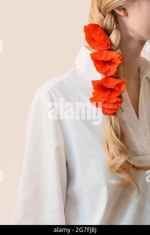 Belles fleurs de pavot rouge dans les cheveux de la femme sur fond clair Banque D'Images
