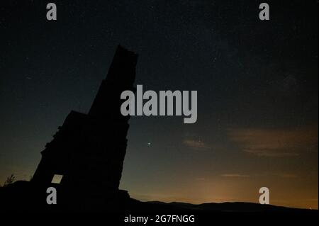 Vorderweidenthal, Allemagne. 10 juillet 2021. Les étoiles se tiennent dans le ciel au-dessus des ruines du château de Lindelbrunn. La Réserve de biosphère forestière du Palatinat a lancé le projet du parc forestier des étoiles du Palatinat afin de sensibiliser le public à la pollution lumineuse. (À dpa 'l'Astrotourisme dans la tendance - le projet doit réduire la pollution lumineuse') crédit: Sebastian Gollnow/dpa/Alamy Live News Banque D'Images