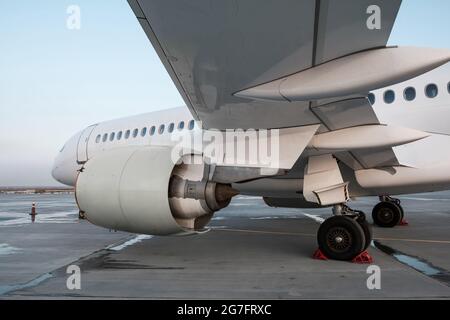 Vue rapprochée d'un avion à réaction passager blanc depuis le dessous de l'aile Banque D'Images