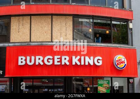 Londres, Royaume-Uni. 13 juillet 2021. Des fenêtres sur le restaurant Burger King de Leicester Square à Londres ont été vues à bord après que les fans de football de l'Angleterre leur ont lancé des bouteilles avant la finale de l'Euro 2020 dimanche. Crédit : SOPA Images Limited/Alamy Live News Banque D'Images